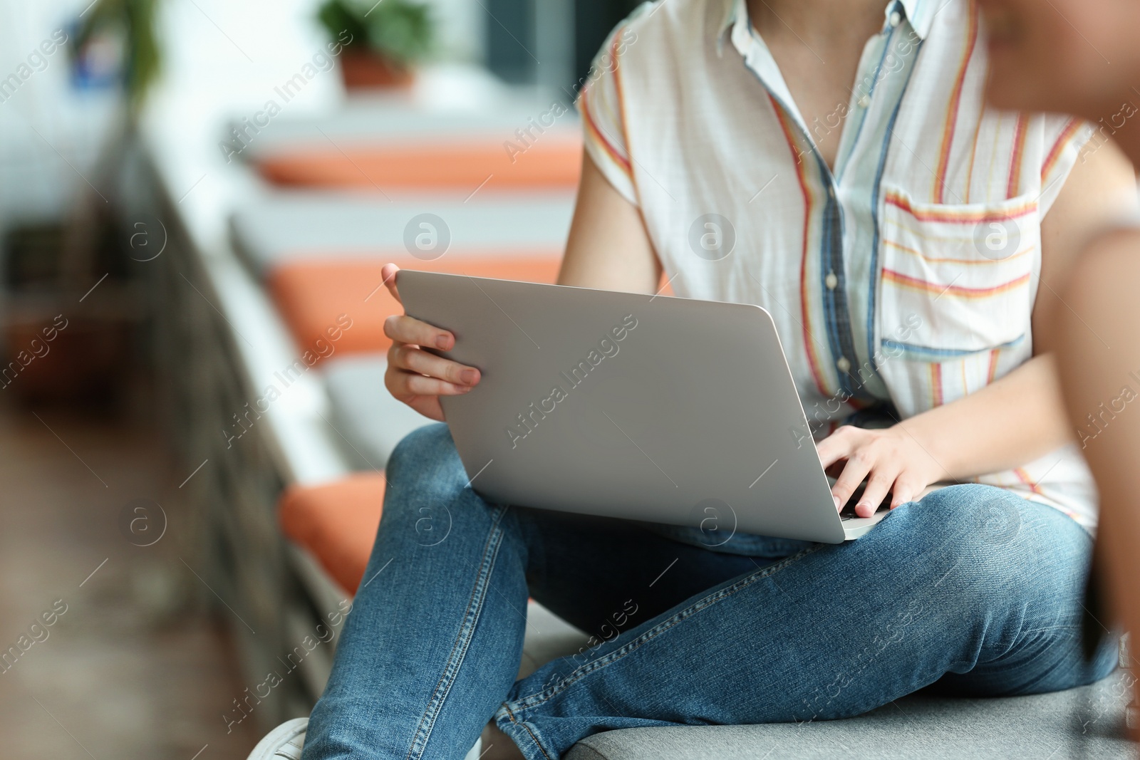 Photo of Young woman working on laptop in library, closeup