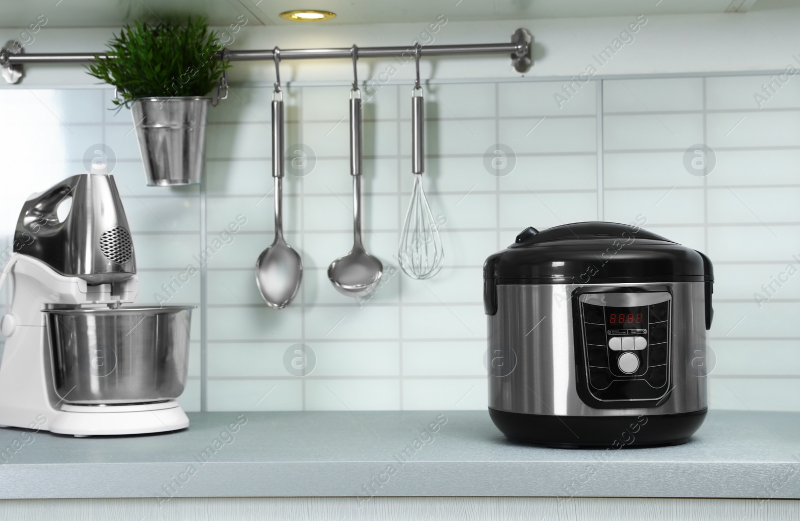 Photo of Modern multi cooker and mixer on table in kitchen. Space for text