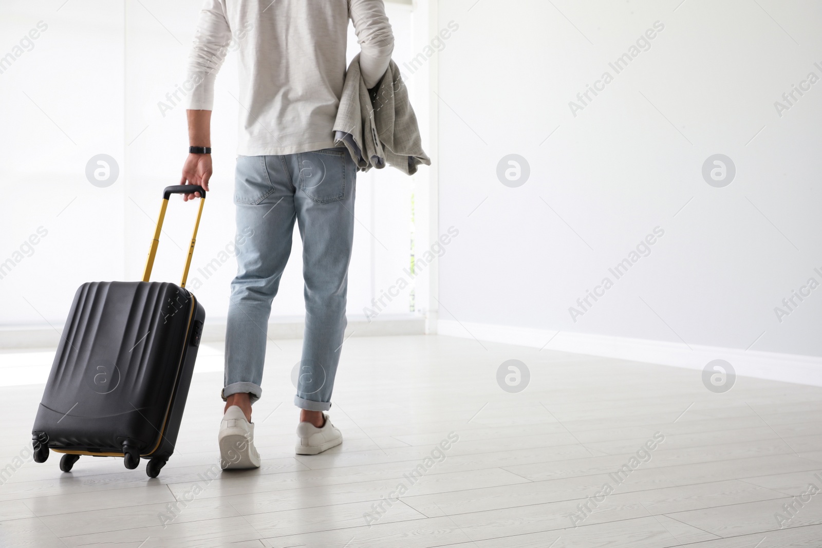 Photo of Man with black travel suitcase in airport. Space for text