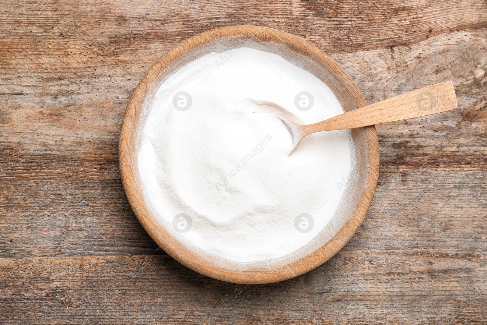 Photo of Plate with baking soda on wooden background, top view