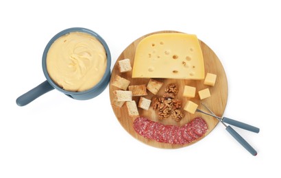 Photo of Fondue with tasty melted cheese, forks and different snacks isolated on white, top view