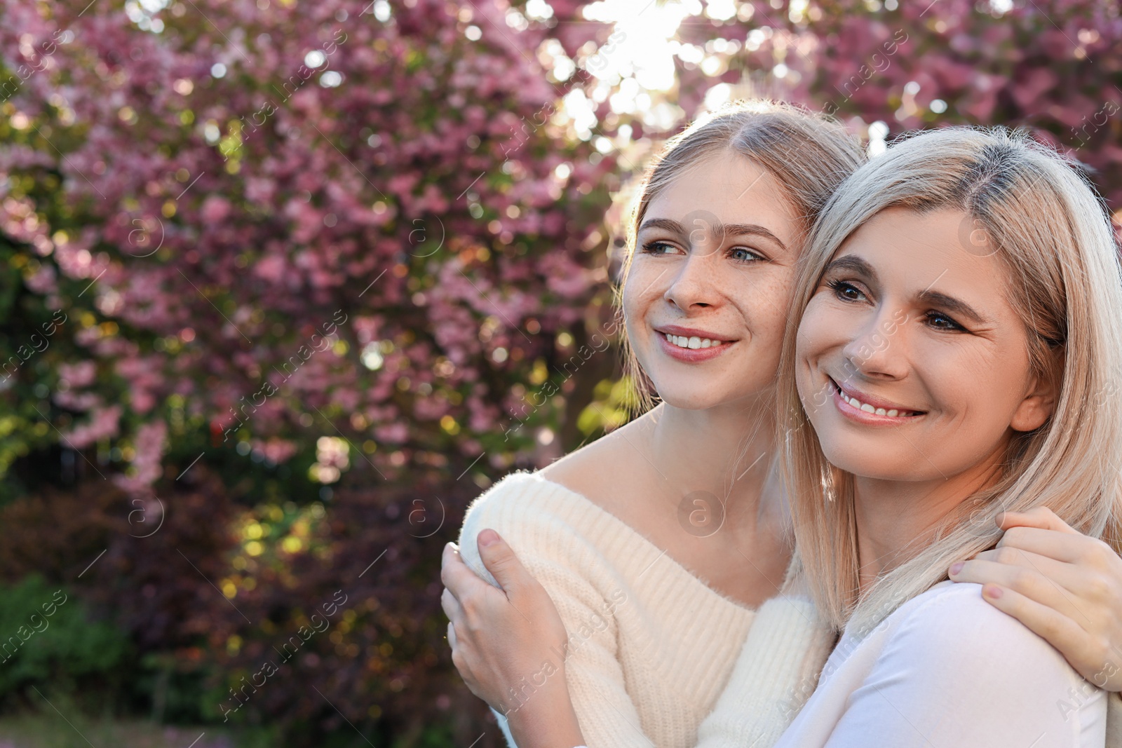 Photo of Happy mother with her daughter spending time together in park on sunny day