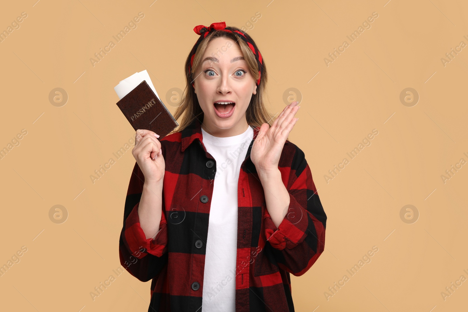 Photo of Emotional young woman with passport and ticket on beige background