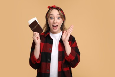 Emotional young woman with passport and ticket on beige background