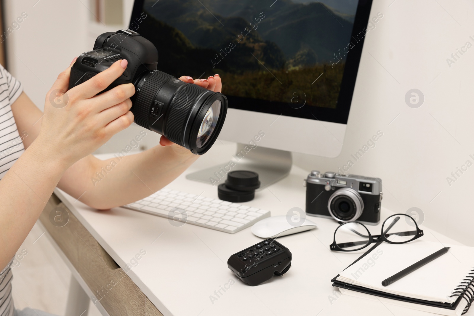 Photo of Photographer with camera at white table indoors, closeup