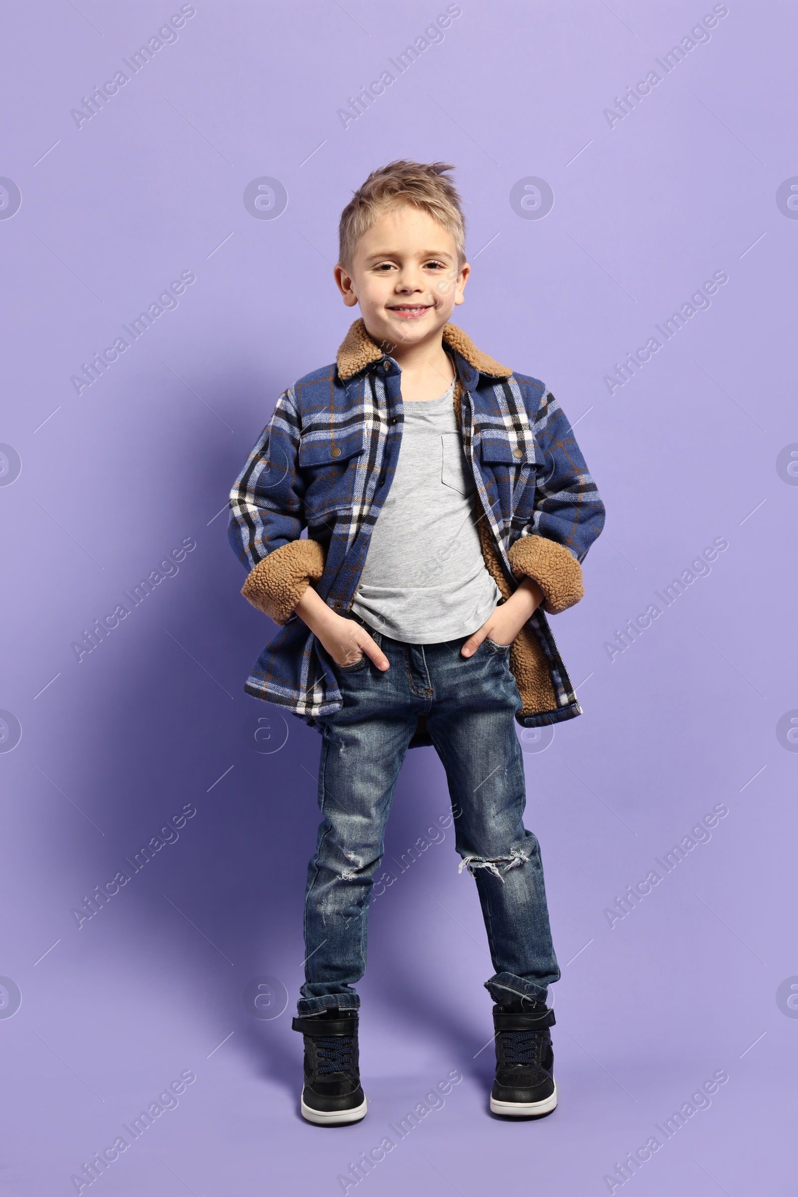 Photo of Fashion concept. Stylish boy posing on violet background