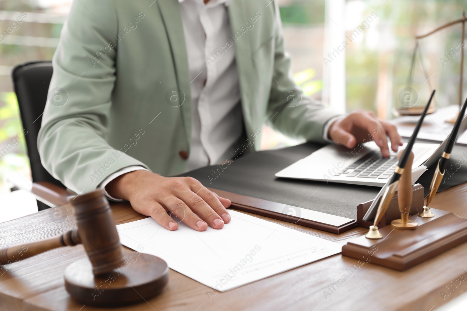 Photo of Male notary working with laptop at table in office, closeup