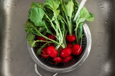 Pouring tap water into colander with radish in sink, top view