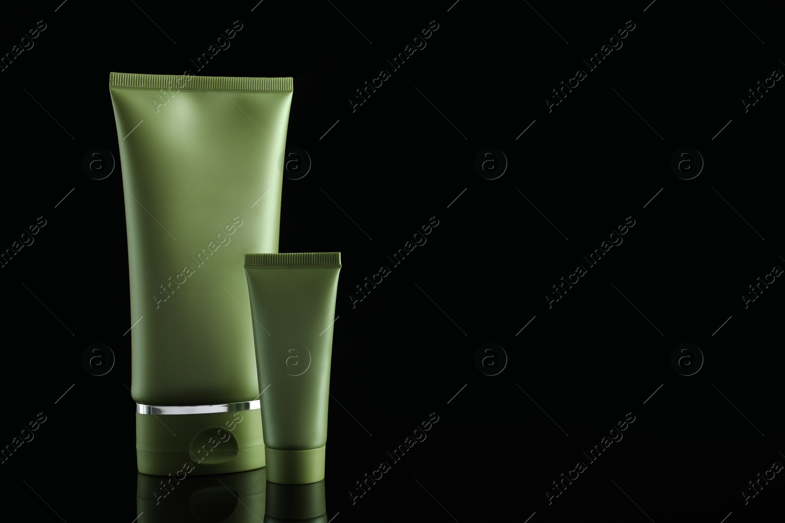 Photo of Tubes of cosmetic products on black background, space for text