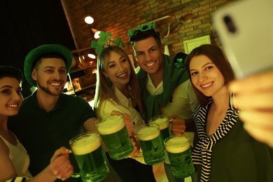 People with beer taking selfie in pub. St Patrick's day celebration