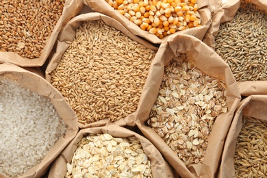 Photo of Paper bags with different types of grains and cereals as background