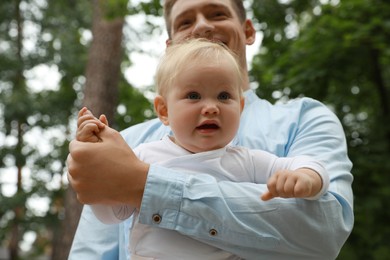 Father with his cute child spending time together outdoors, selective focus