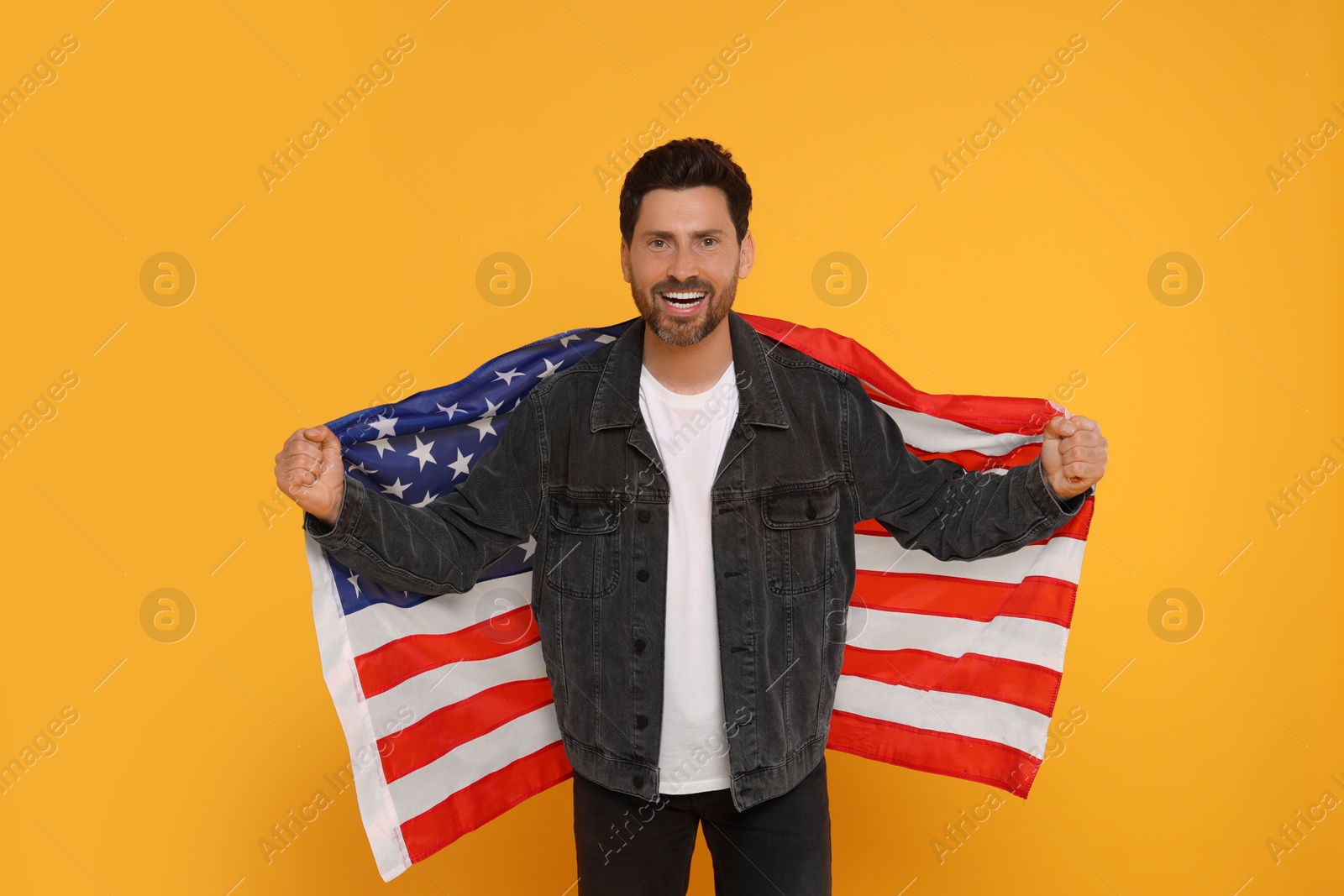 Photo of 4th of July - Independence Day of USA. Happy man with American flag on yellow background