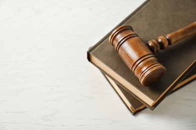 Wooden gavel and books on light table. Law concept