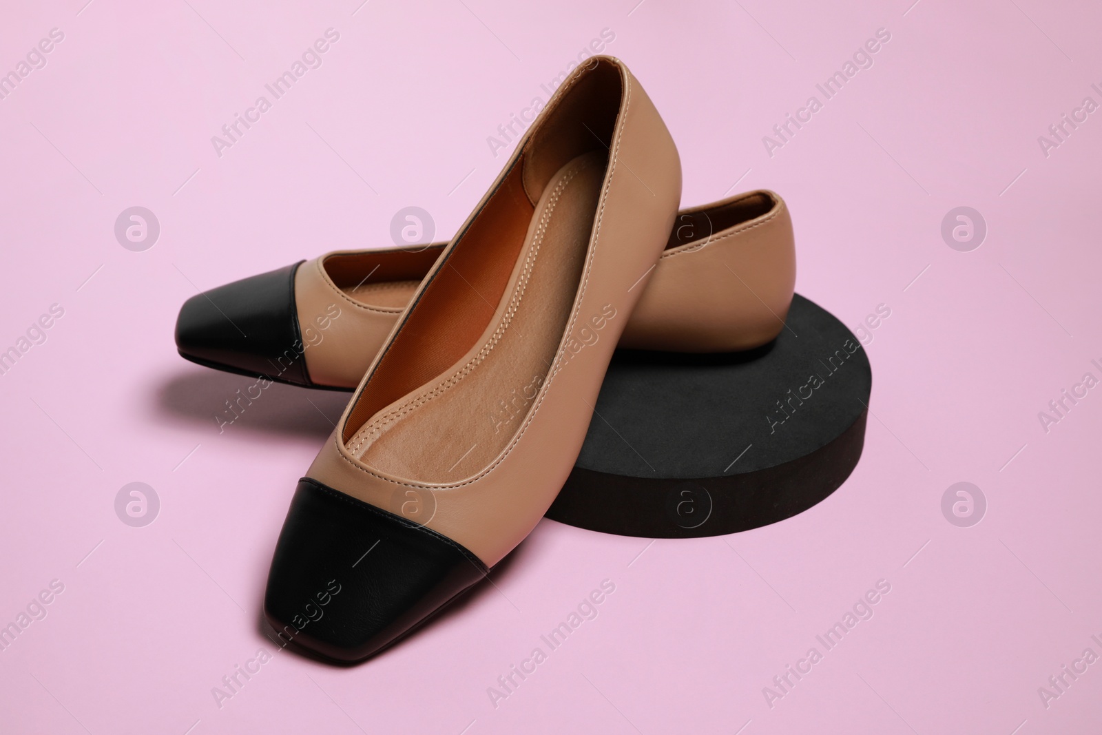 Photo of Pair of new stylish square toe ballet flats on pale pink background