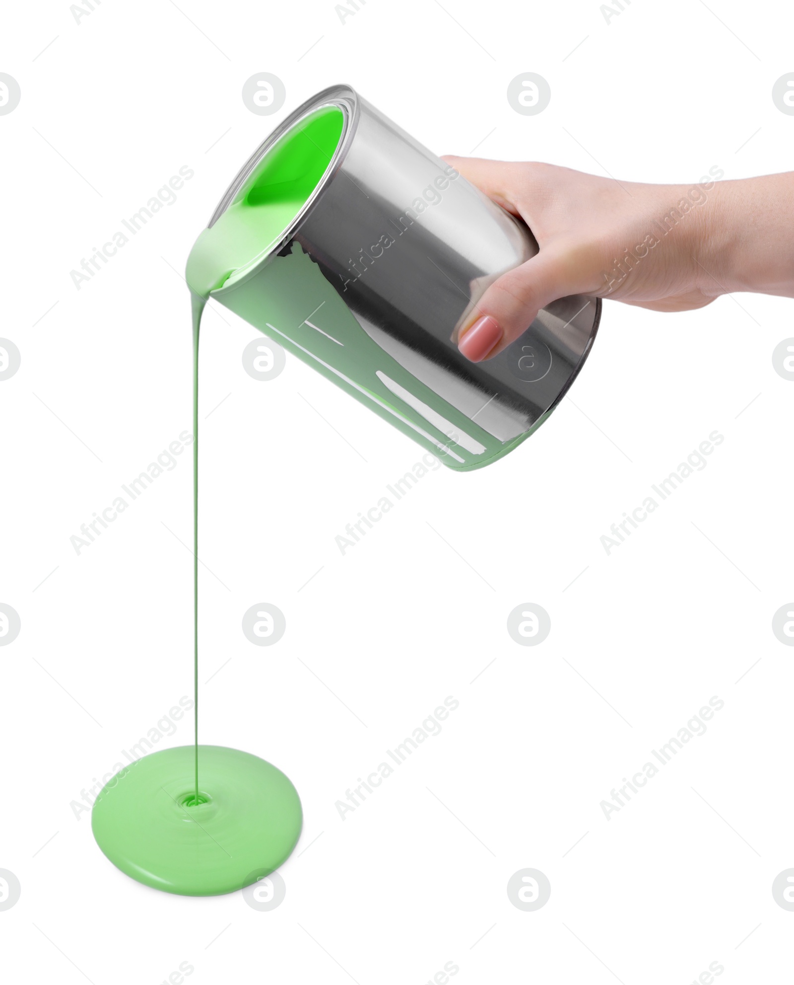 Photo of Woman pouring light green paint from can on white background, closeup