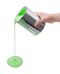 Woman pouring light green paint from can on white background, closeup