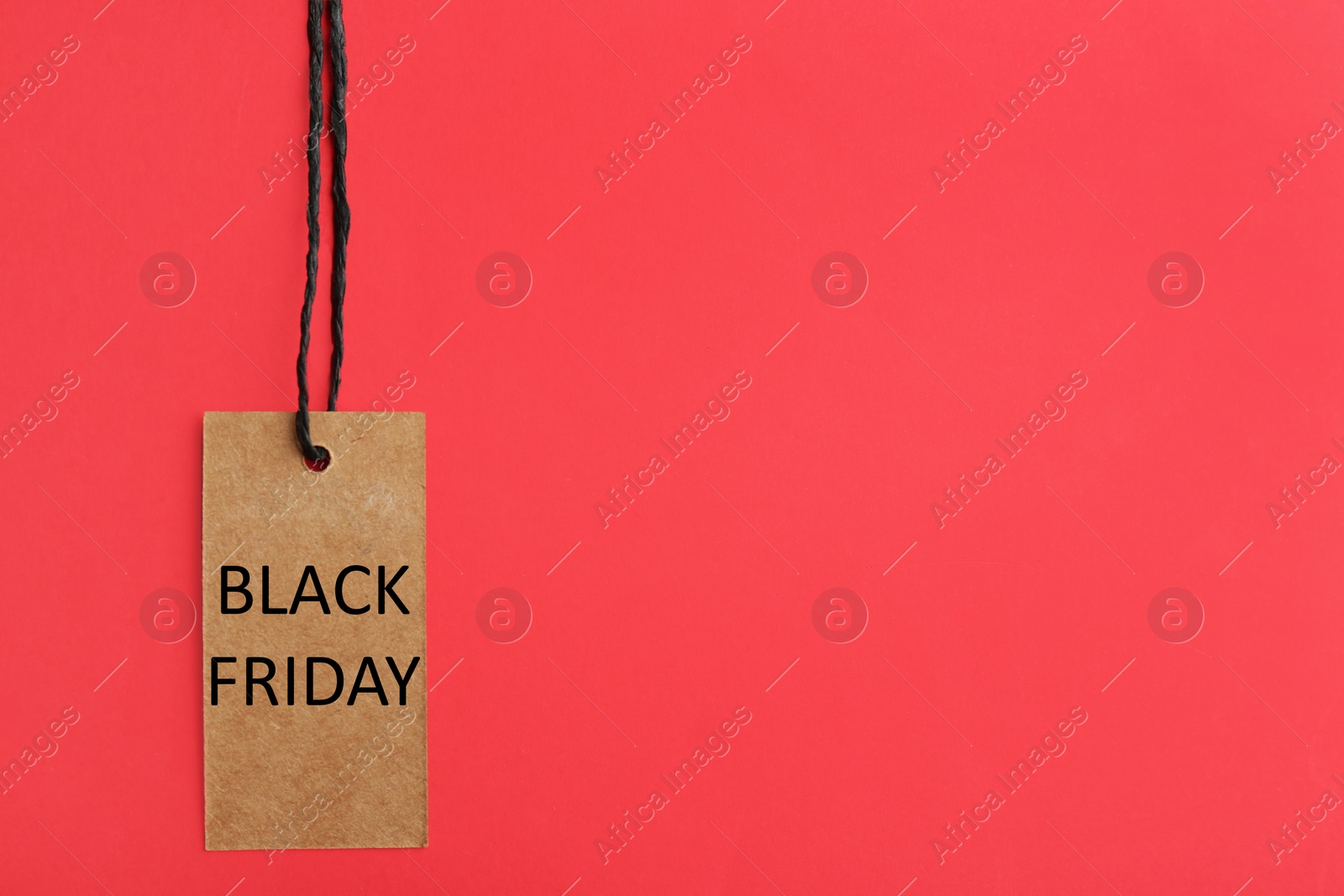 Photo of Tag with words BLACK FRIDAY on red background, top view. Space for text