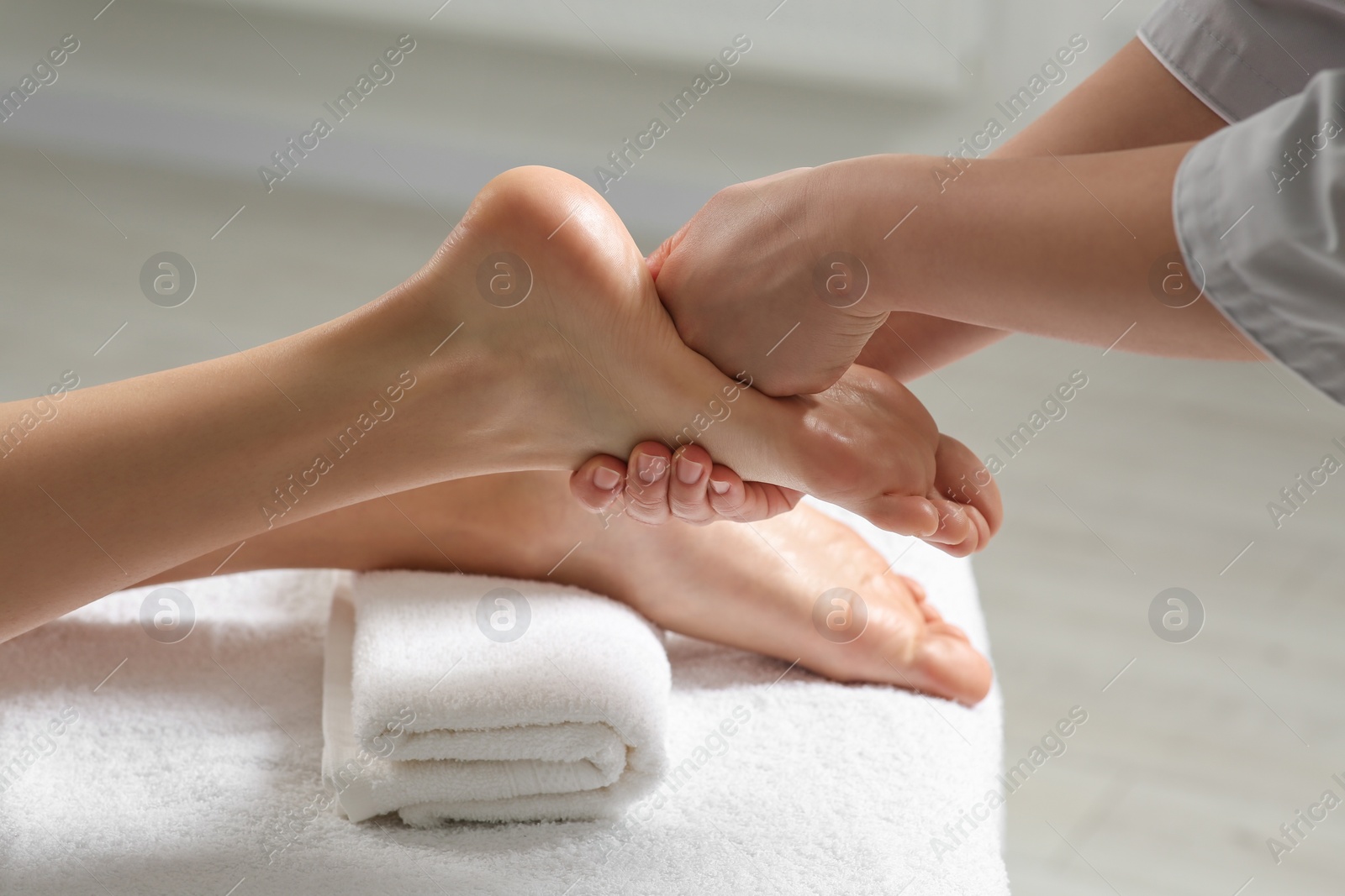 Photo of Woman receiving foot massage in spa salon, closeup