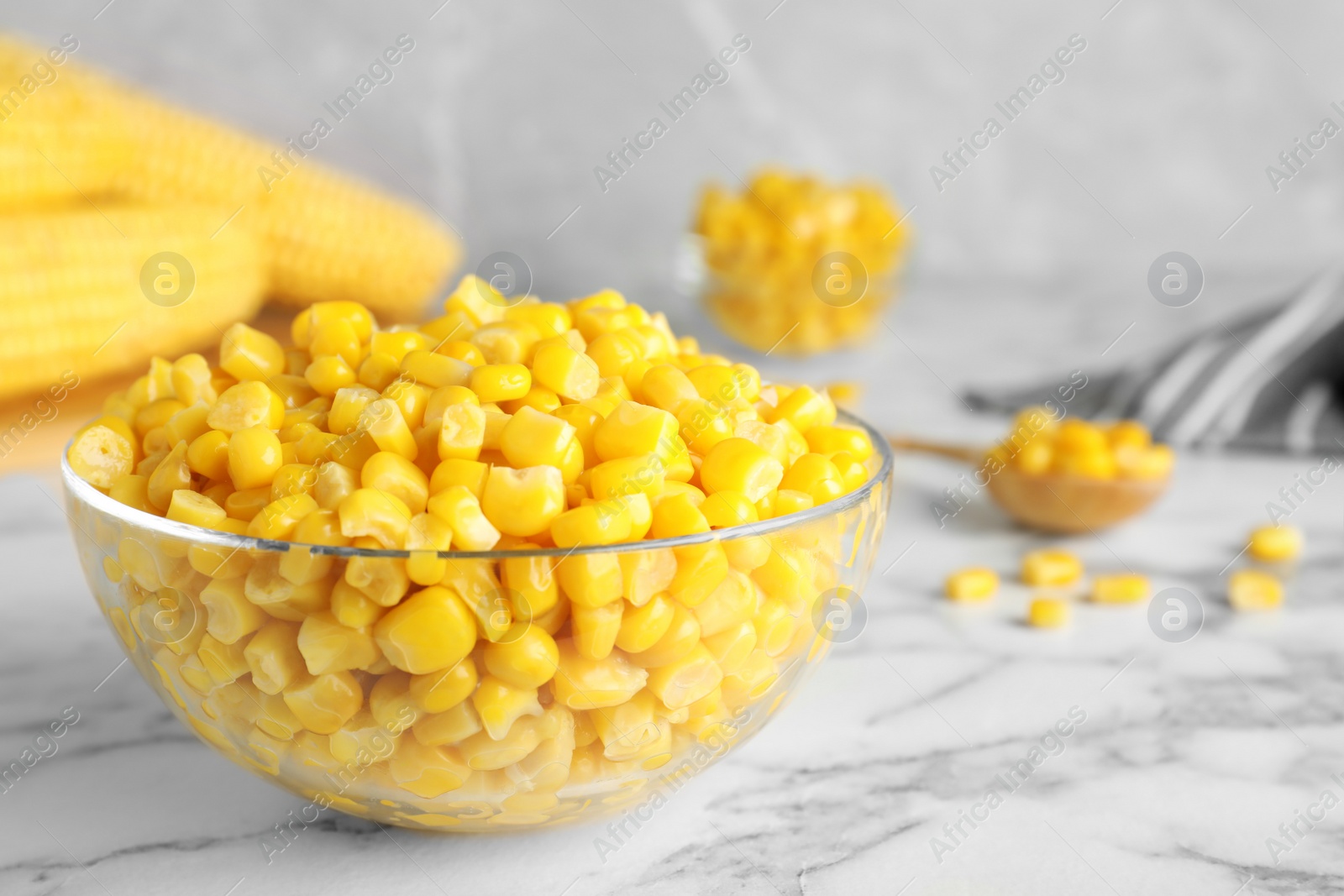 Photo of Delicious canned corn in bowl on marble table, closeup