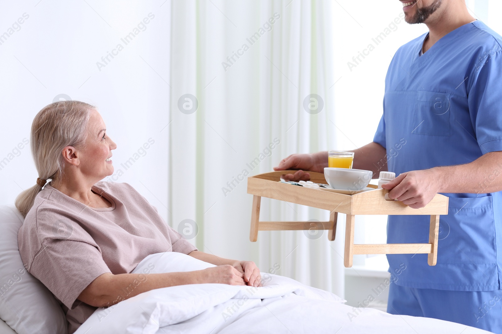 Photo of Male nurse bringing food and medicine for patient in hospital ward. Doctor's prescription