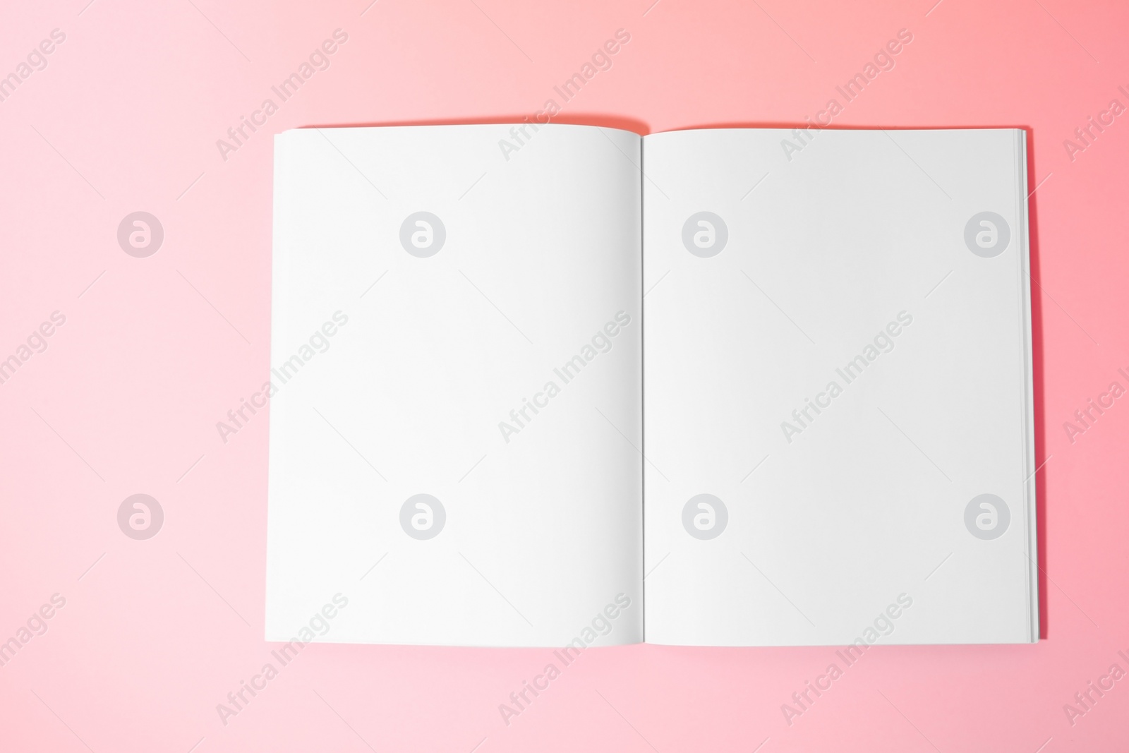 Photo of Empty book pages on pink background, top view. Mockup for design