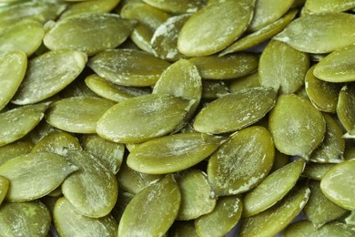 Many peeled pumpkin seeds as background, closeup