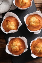 Photo of Delicious sweet muffins on wooden table, top view