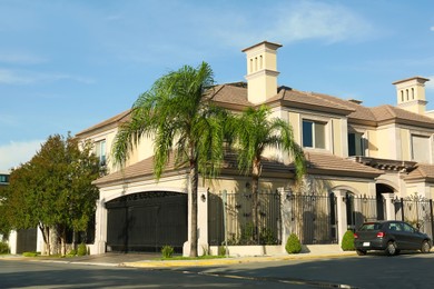 Beautiful modern house and palm trees in city street