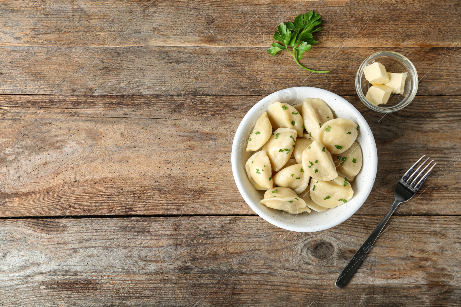 Photo of Delicious cooked dumplings served on wooden table, flat lay. Space for text