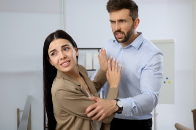 Young woman fighting with man in office
