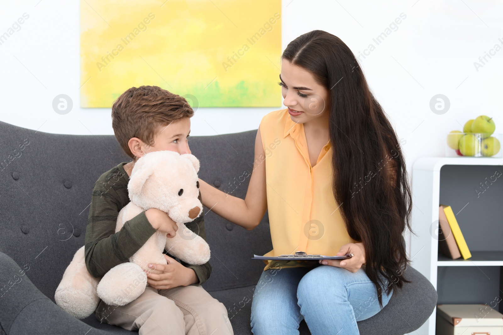 Photo of Child psychologist working with boy in office