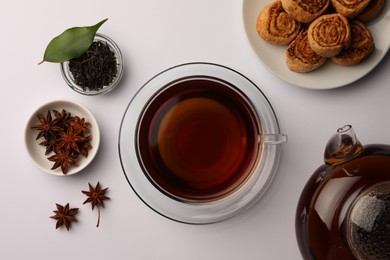 Flat lay composition with aromatic tea, cookies and anise stars on white table