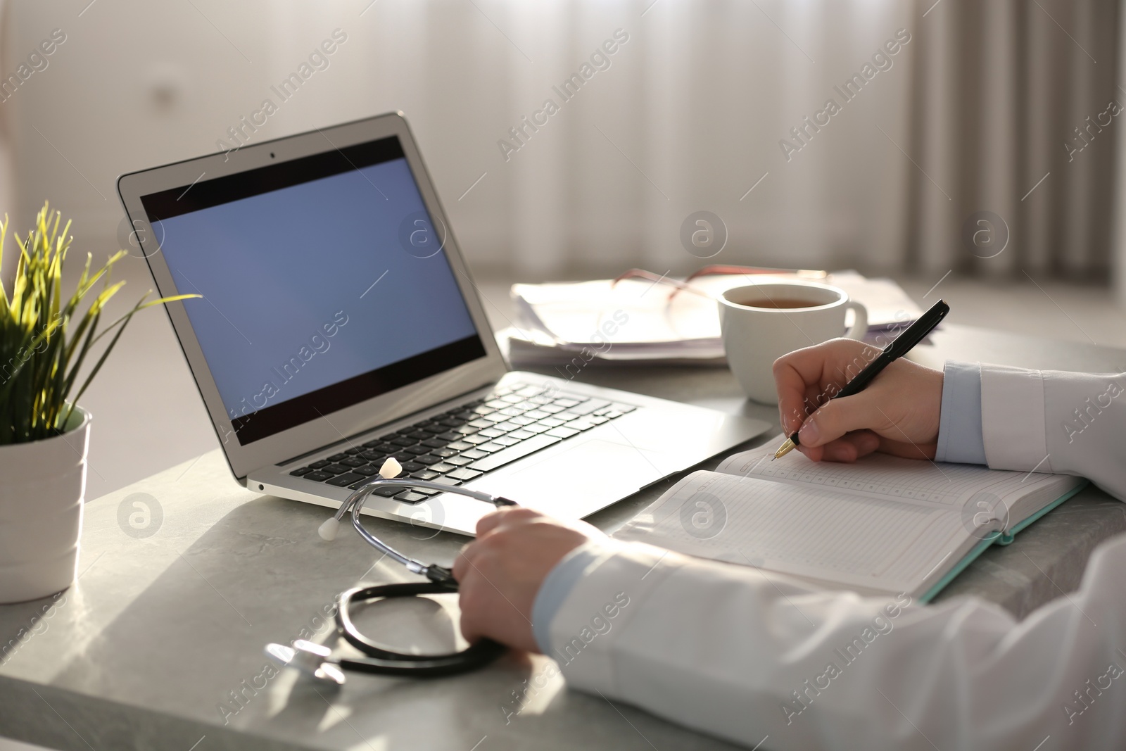 Photo of Professional doctor working at table in office, closeup