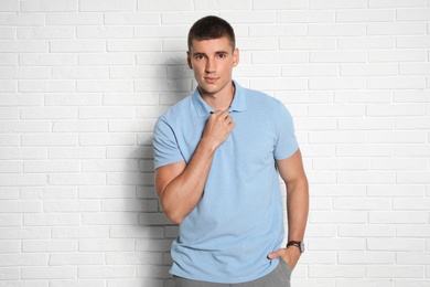 Photo of Portrait of handsome young man on white brick wall