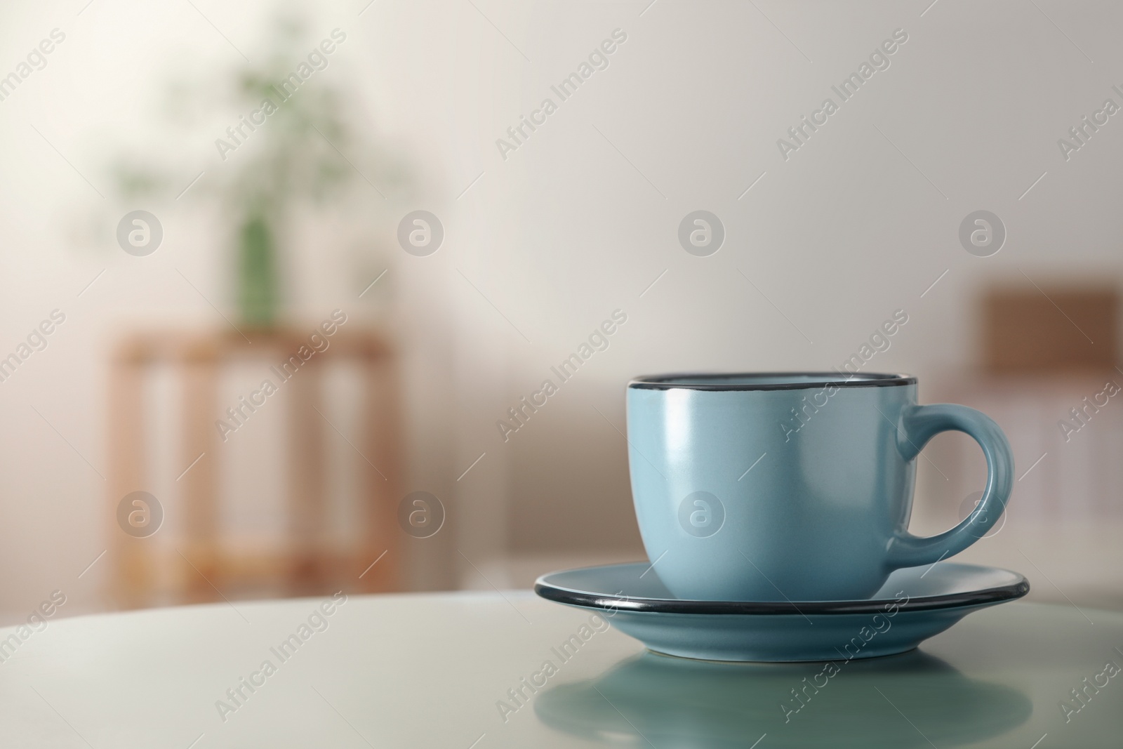 Photo of Ceramic cup on table in room, space for text