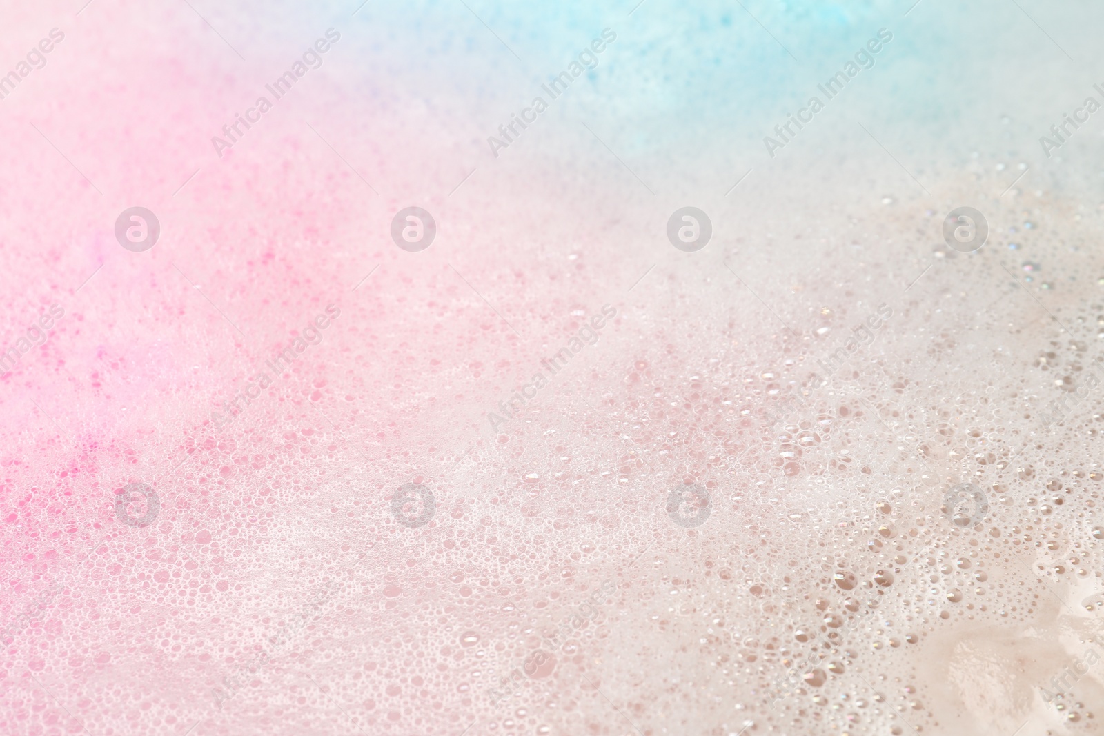 Photo of Colorful foam after dissolving bath bomb in water, closeup