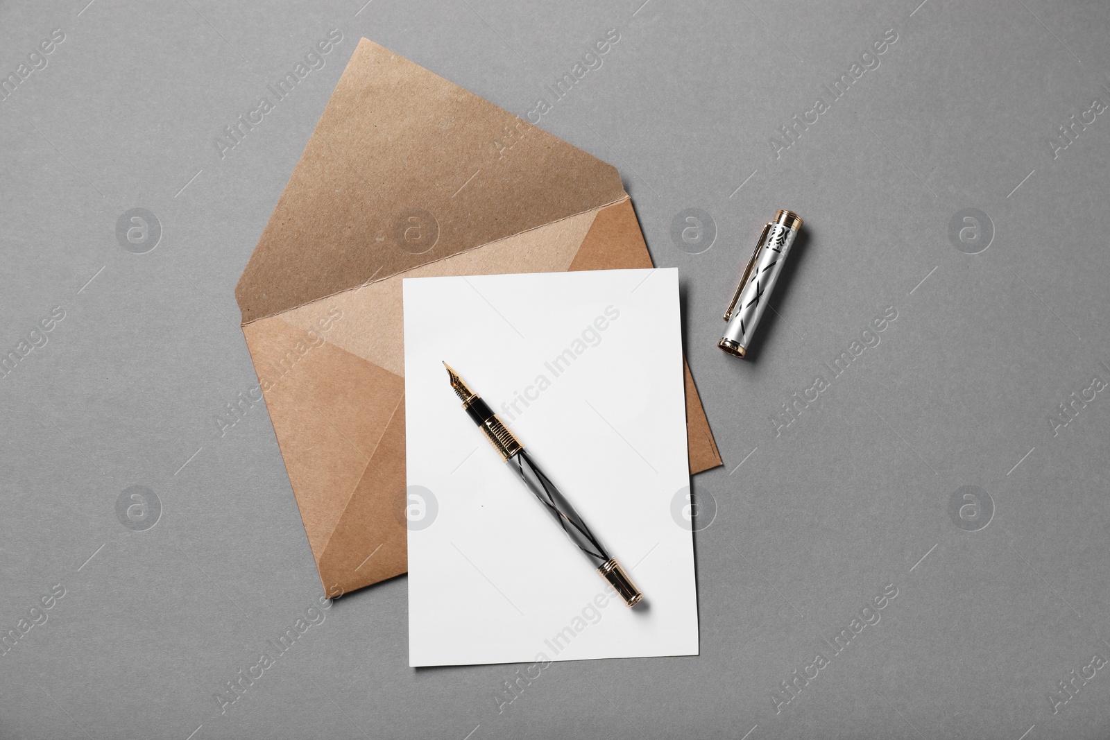 Photo of Blank sheet of paper, letter envelope and pen on grey background, top view