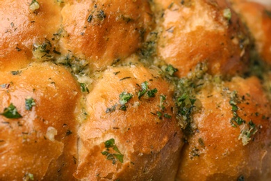 Photo of Buns of bread with garlic and herbs as background, closeup