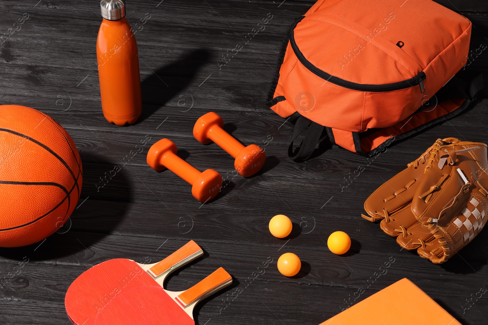 Photo of Many different sports equipment on dark grey wooden table