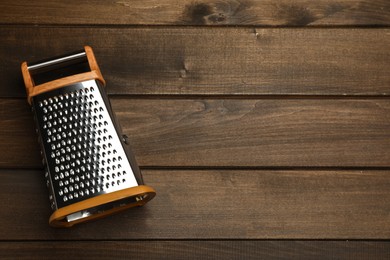 Photo of Modern grater on wooden table, top view. Space for text