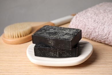 Photo of Natural tar soap on wooden table, closeup