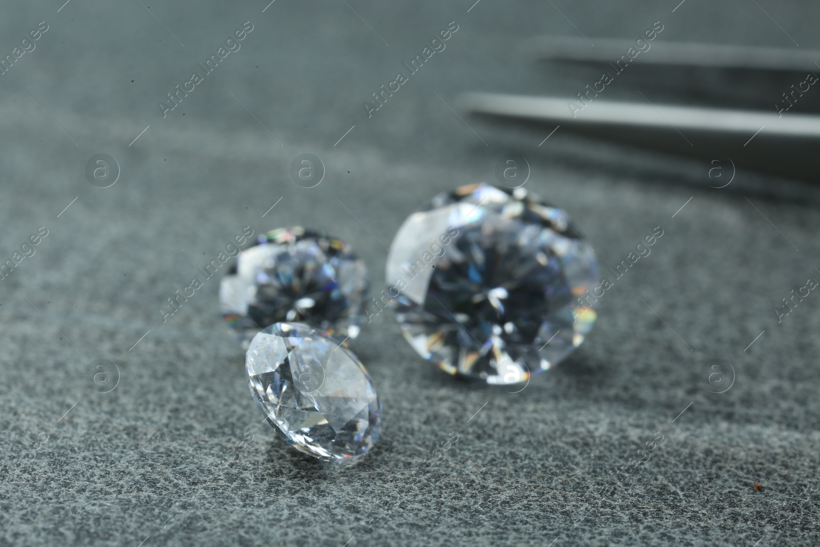 Photo of Different beautiful shiny diamonds on grey background
