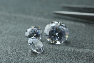 Photo of Different beautiful shiny diamonds on grey background