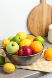 Photo of Metal colander with different fruits on countertop in kitchen