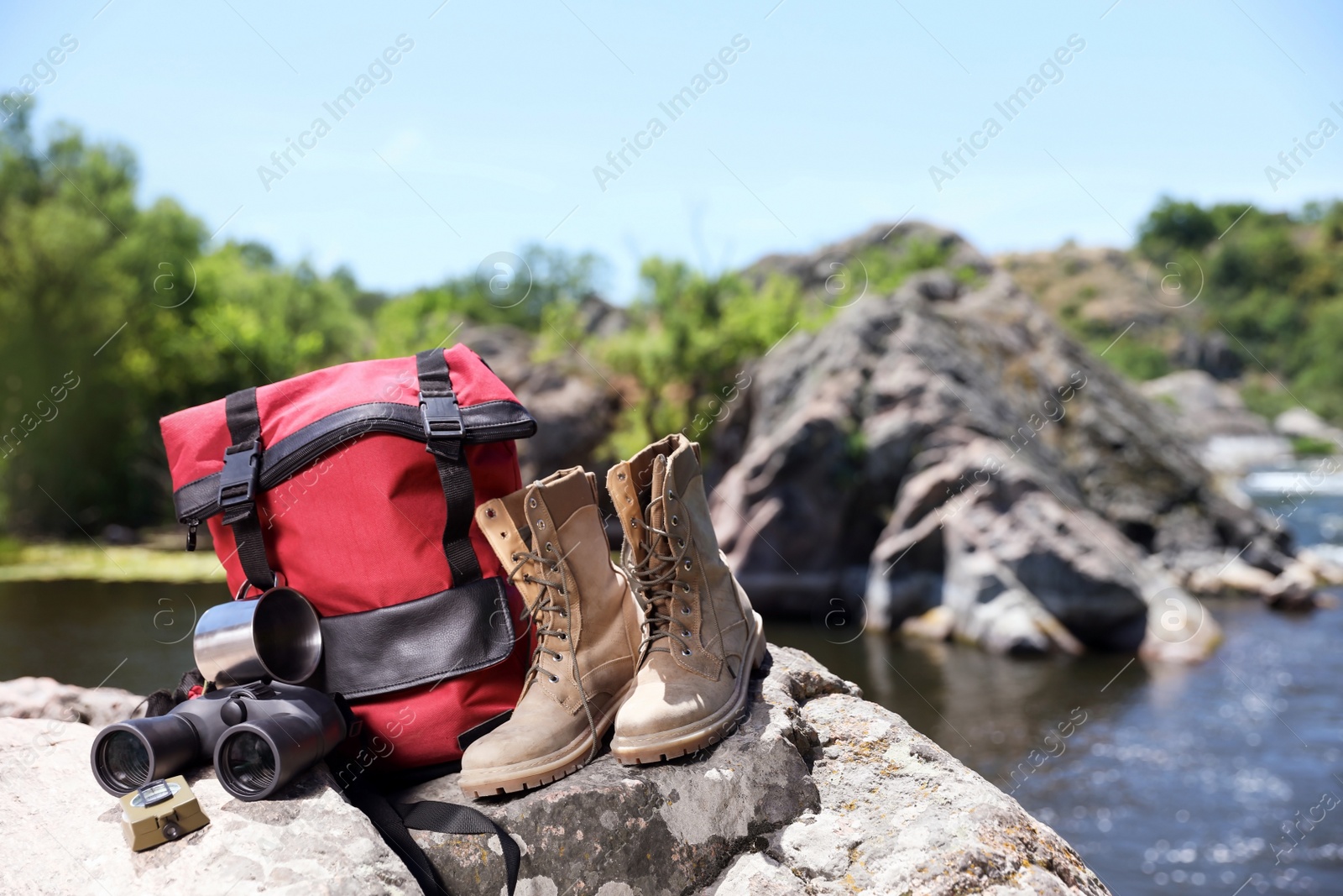 Photo of Traveling gear on rock near river. Summer camp