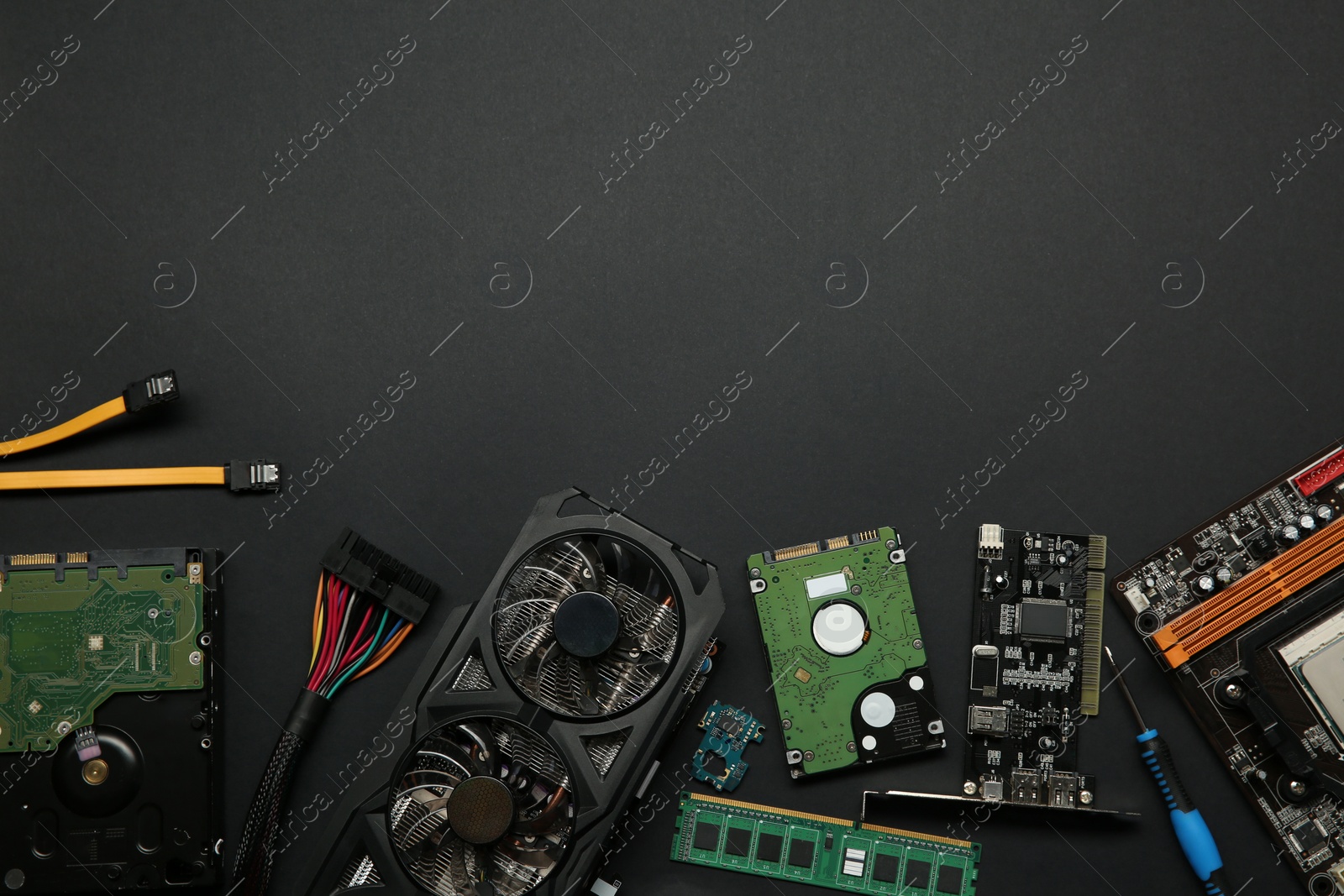 Photo of Graphics card and other computer hardware on black background, flat lay. Space for text