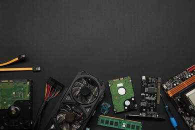 Graphics card and other computer hardware on black background, flat lay. Space for text