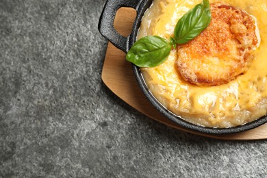 Photo of Tasty homemade french onion soup served on grey table, top view. Space for text