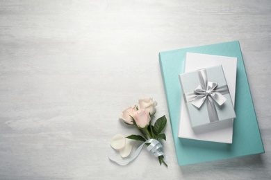 Photo of Elegant gift boxes and beautiful flowers on white table, flat lay. Space for text
